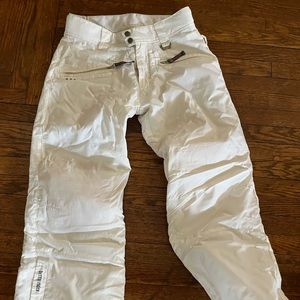 White Betty rides small snowboard /ski pants.